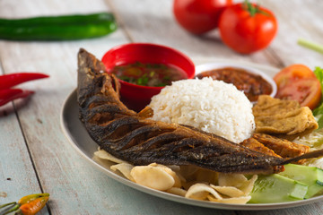 fried catfish with rice , sambal , vegables and mixed dish