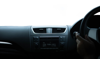 Driver's hand on the black steering wheel with dashboard inside of a car isolated on white background.
