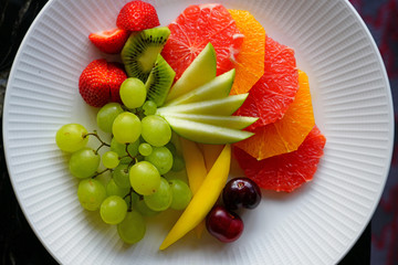 A healthy fruit plate with grapes, apple and grapefruit