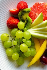 A healthy fruit plate with grapes, apple and grapefruit