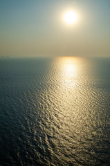 Sunset and reflection over the ocean on a smoggy day