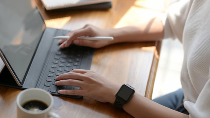 Side view of female freelancer working on digital tablet