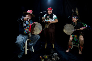 group of shaman Teotihuacanos, Xicalanca - Toltec in black background, with traditional dress dance with a trappings with feathers and drum