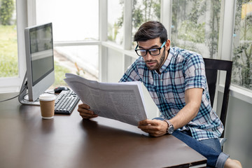 Caucasian man reading business news.