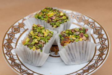 Three slices of fruit and nut pistachio lokum on a saucer, a tra