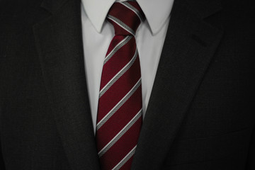 Man in grey suit with red and white tie