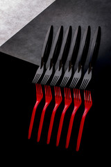 Still life with red and black forks