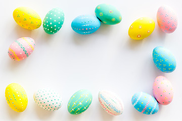 Colorful Easter eggs frame on white background top-down copy space
