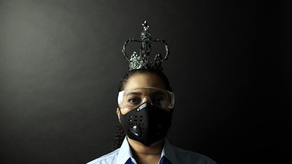 Woman in urban protective air mask with glasses, wearing crown or corona. Coronavirus pathogen outbreak pandemic concept. Virus disease 2019-nCoV or covid-19 protection and prevention.