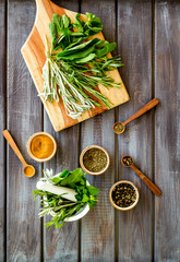 Herbs and spices on dark wooden kitchen desk top-down