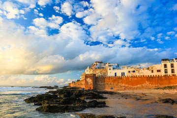 Ancient walls of the medina in Essaouira at sunset clouds, photographed using a polarizing filter - obrazy, fototapety, plakaty