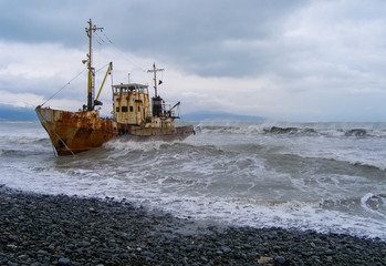 Abandoned fishing boat beached by the strong storm