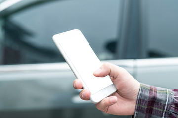 Close up of human hand using smartphone in a car