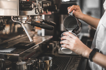 barista pouring hot coffee in machine