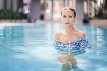 Enjoying vacation. Sensual portrait of  beautiful young woman in swimming pool.