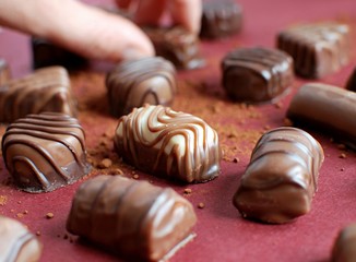 Close up view of different chocolate candies on red background.