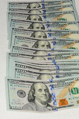 One hundred dollars pile as background.