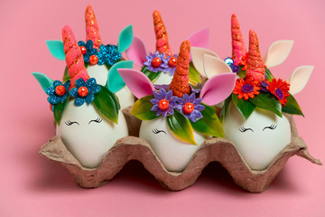 close up cute unusual Easter unicorn eggs on a pink background with copy space