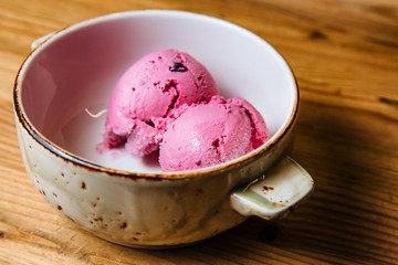 Ice cream in bowl on a wooden table.