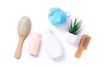  Flat lay organic bath products, herbal cosmetics. Wooden hair brush, shampoo, hair conditioner with aloe vera extract, wooden comb and blue sponge