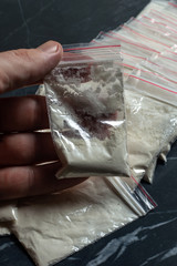 drug trade: a dope sachet against the backdrop of many packaged doses of cannabis cocaine and heroin