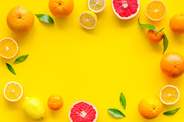 Citrus fruits - lemons, grapefruits - on yellow background mockup, frame top-down copy space