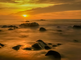 Fototapeta na wymiar view seaside evening of many arch rocks in the sea around with silky water and yellow sun light in the sky background, sunset at Khao Lak-Lam Ru National Park, Phang Nga, southern of Thailand.