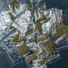 crime evidence: many packaged doses of cannabis lie on a dark surface