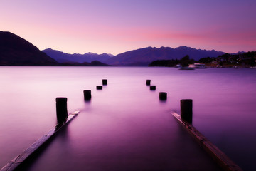 Picturesque sunset landscape wharf on lake in mountains. Lake Wanaka, New Zealand.