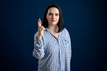 Young woman dressed casually showing good luck