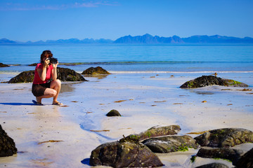 Woman take photo on beach, Lofoten Norway