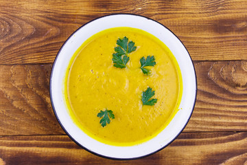 Pumpkin soup on a wooden table. Top view