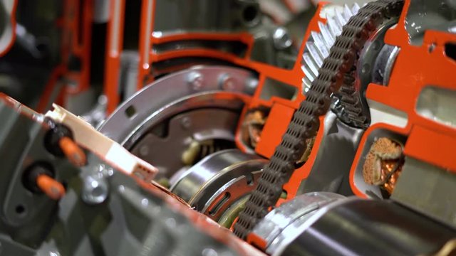 Close up shot of rotating car engine chain. Metal chain spinning in auto service, repair workshop