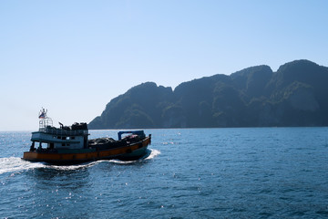 local fihsing boat in thailand with mountains in the background