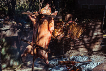 Traditional suckling pig cooked on the charcoal grill. The little pig is roasted whole on an open...