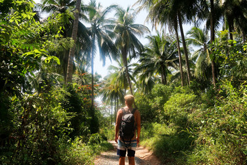 Fototapeta na wymiar man with backpack in incredible lush, tropical jungle in thailand