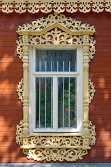 Window in a wooden house with beautiful carved platband