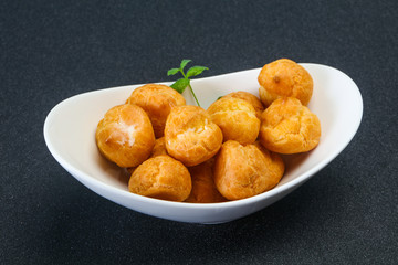 Sweet tasty profiteroles heap in the bowl