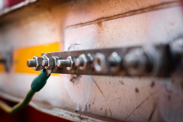 Voltage grounding system on metal structure that used as safety device to transfer leaked electricity current out to earth pit. Safety equipment in industrial operation, close-up and selective focus.