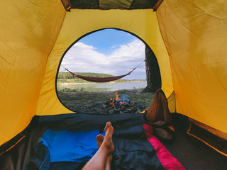 view form camping tent on campfire with hammock near lake