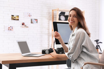 Professional photographer with camera working at table in office