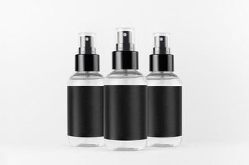 Transparent spray bottles for cosmetics product with black blank label on white background, mock up for branding, advertising, presentation, design.