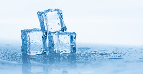 Ice cubes square with drops water clean on blue background