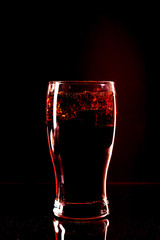 Cola glass with ice cubes and droplets, isolated on black background