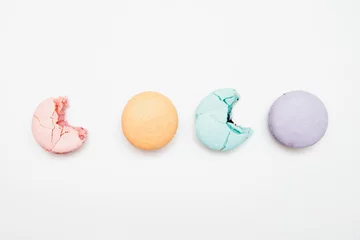 Fototapeten Bunte türkisfarbene, rosa, orange, violette Kuchen Französische Macaron oder Makronen auf weißem Hintergrund gebissen © Parilov