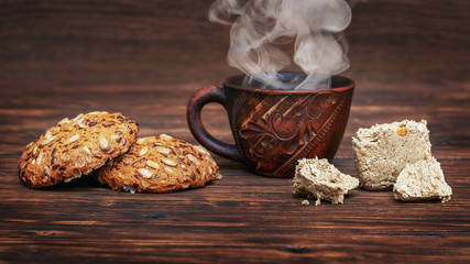 Cup of hot coffee, cookies and halvah on a wooden table_
