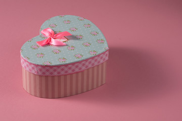 Valentine's Day celebration concept. A nice gift from a loved one. Box with a bow on a delicate pink background. Copy space. Flat lay. Close-up.