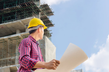 Engineer man with clipping path checking and planning project at construction site, Man holding blueprint and looking into the sky