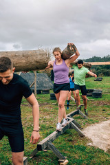 Participants in an obstacle course carrying trunks outdoors