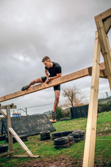 Male participant in a obstacle course doing irish table obstacle